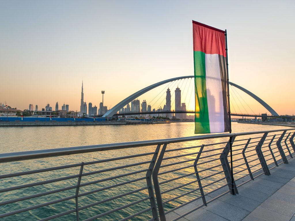 UAE Visa:  United Arab Emirates Flag with water and Burj Khalifa in background