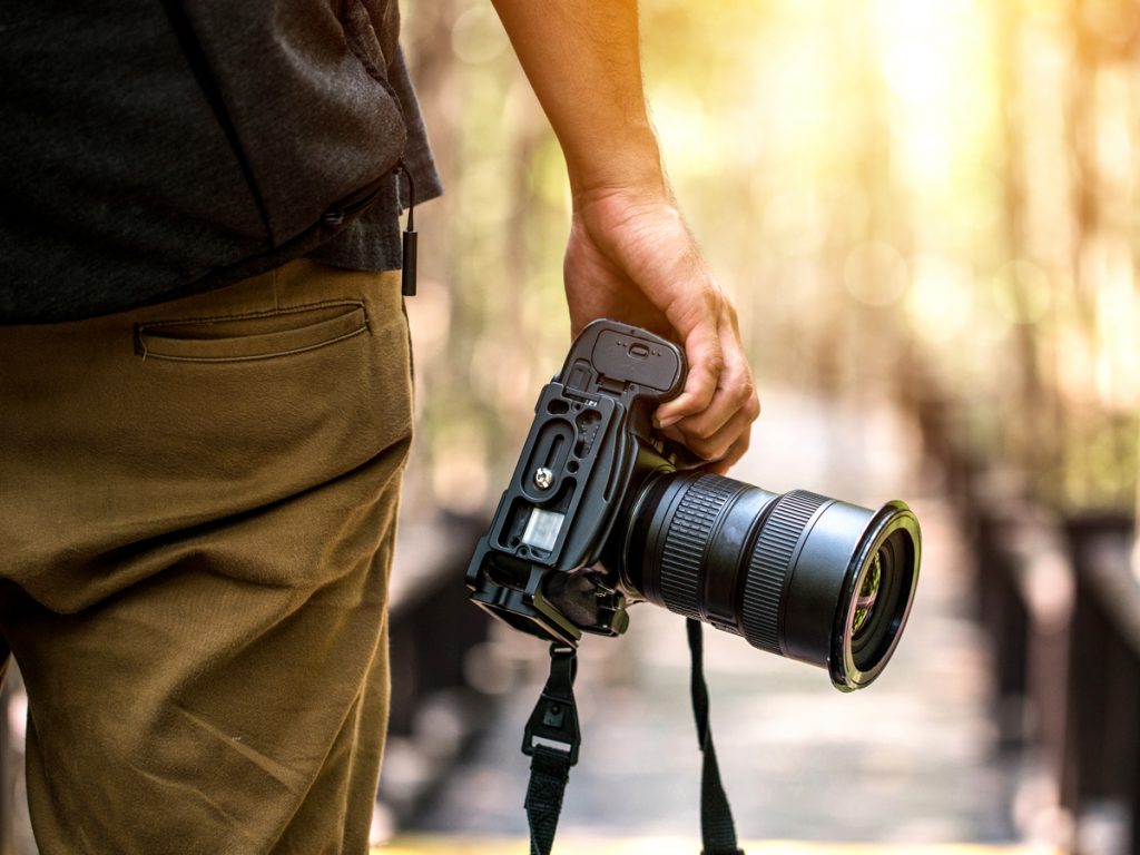 Courses that will change your life: Man holding professional camera