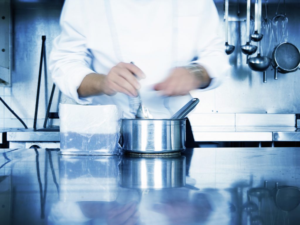 Courses that will change your life: Professional chef wearing chef whites and whisking 