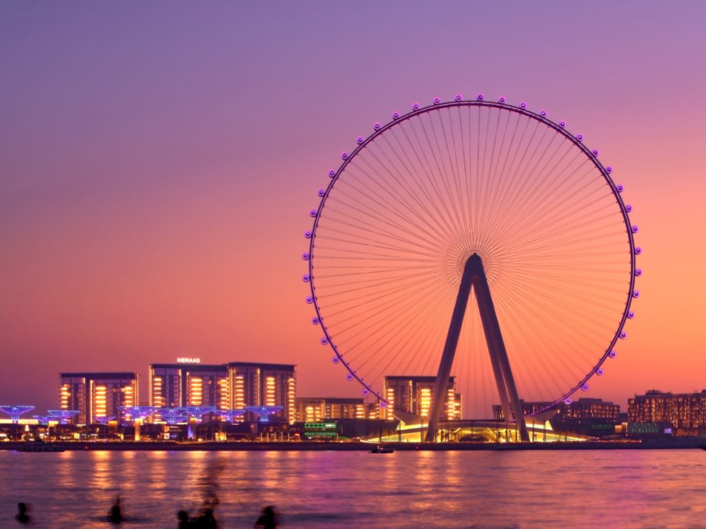 Ain Dubai wheel at dusk with pink sky and Dubai city lights