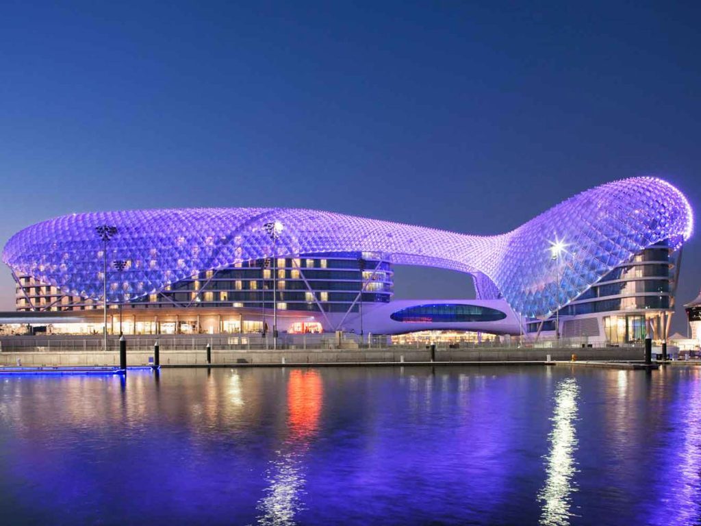 Eid 2022 staycations deals in Abu Dhabi: W hotel at night lit up in blue lights by the water